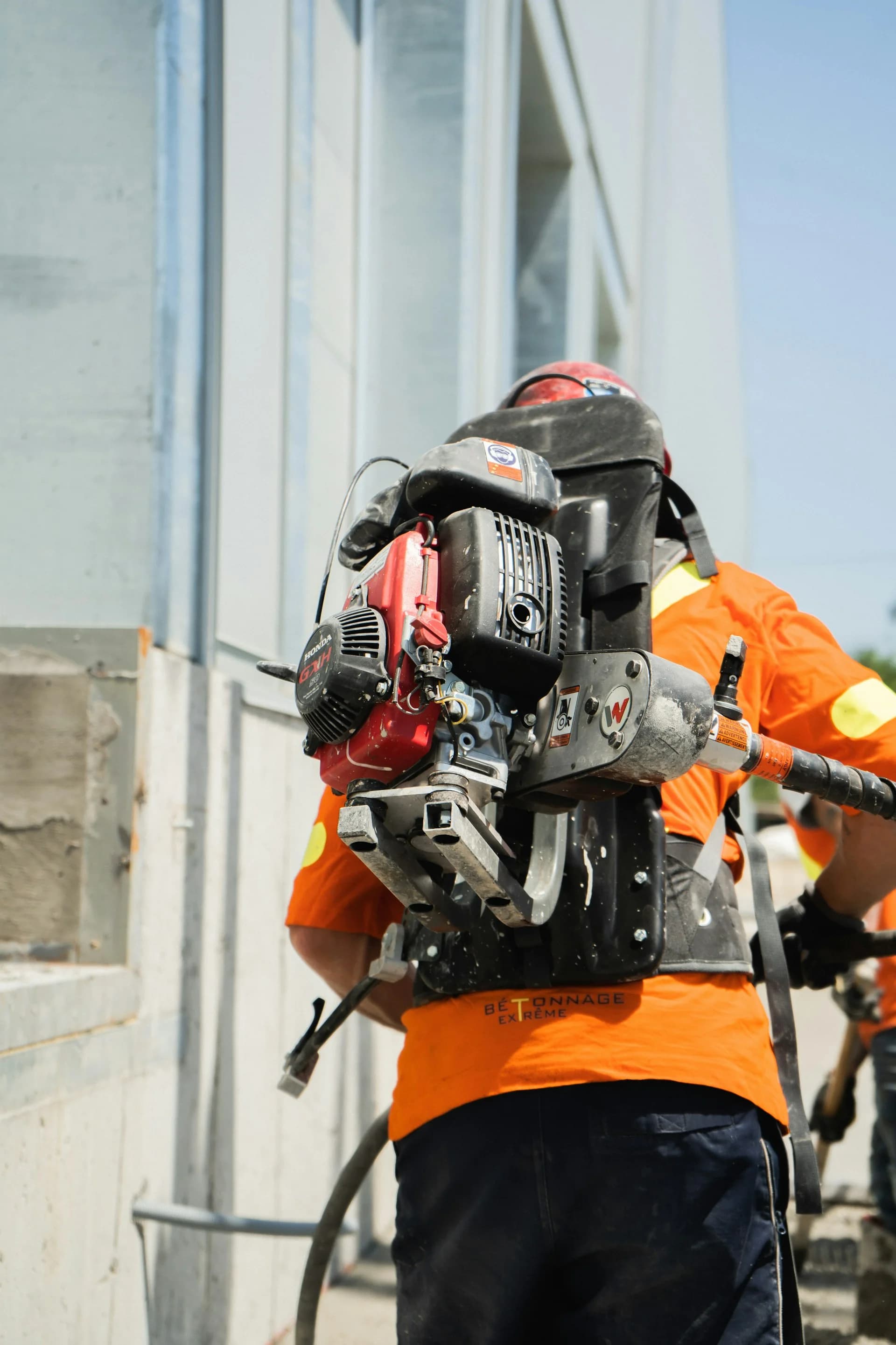Bina cephesinde motorlu kırıcı ekipmanı taşıyan operatör